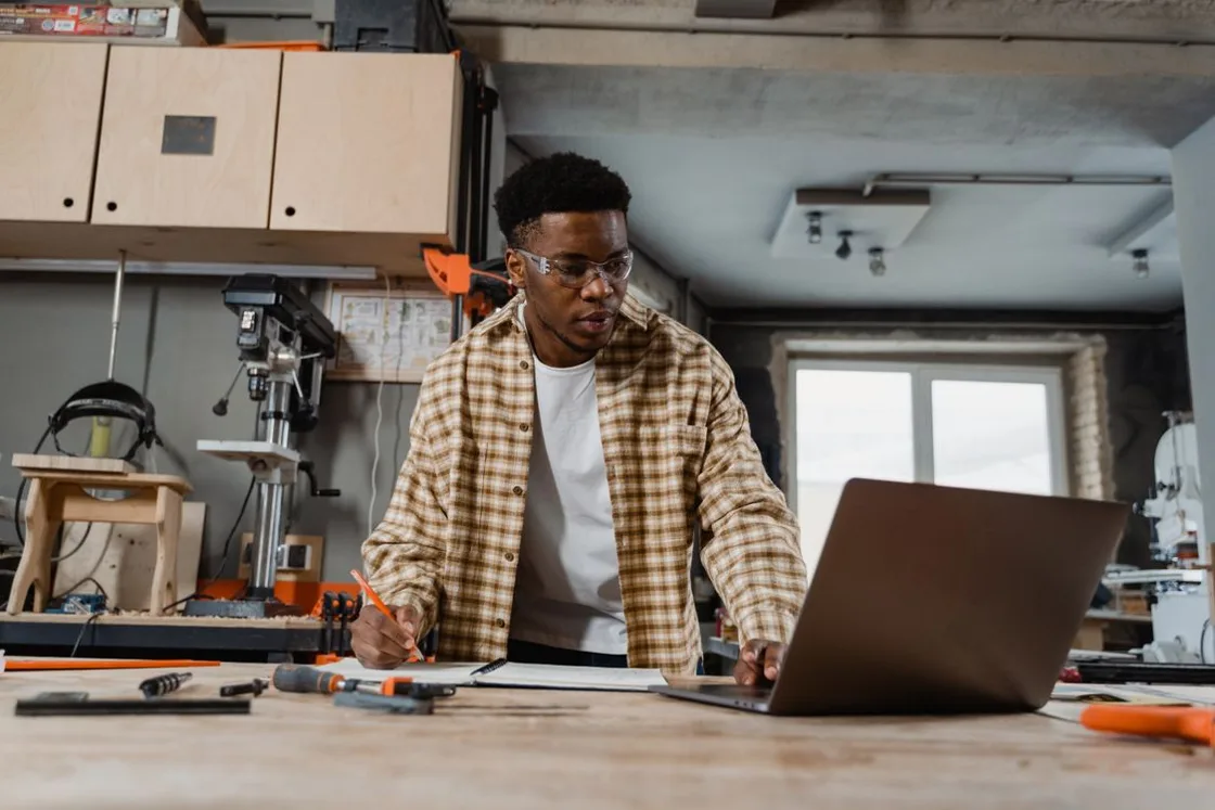 A carpenter planning a job at a workshop bench